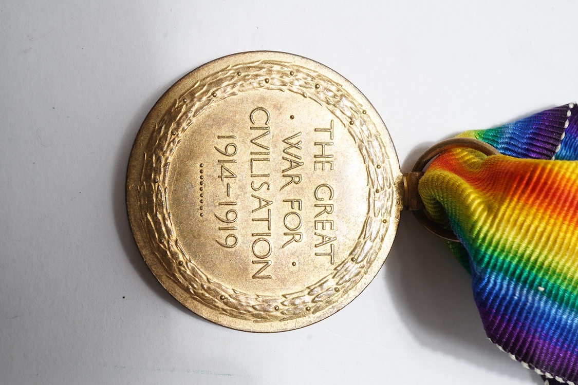 A First World War medal trio awarded to 2140 SJT. G. Watson. Argyll and Sutherland Highlanders, together with the related cap badge and two photographs of Watson in Highlanders uniform and printed as postcards